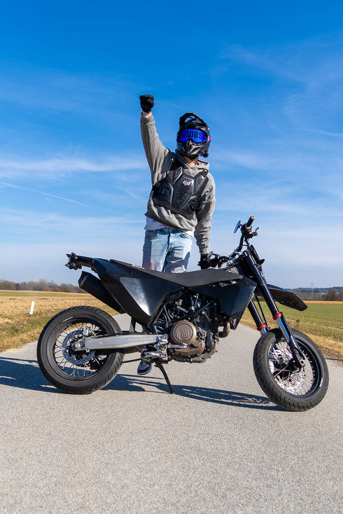 Marron Model in Siegerpose hinter Motorrad